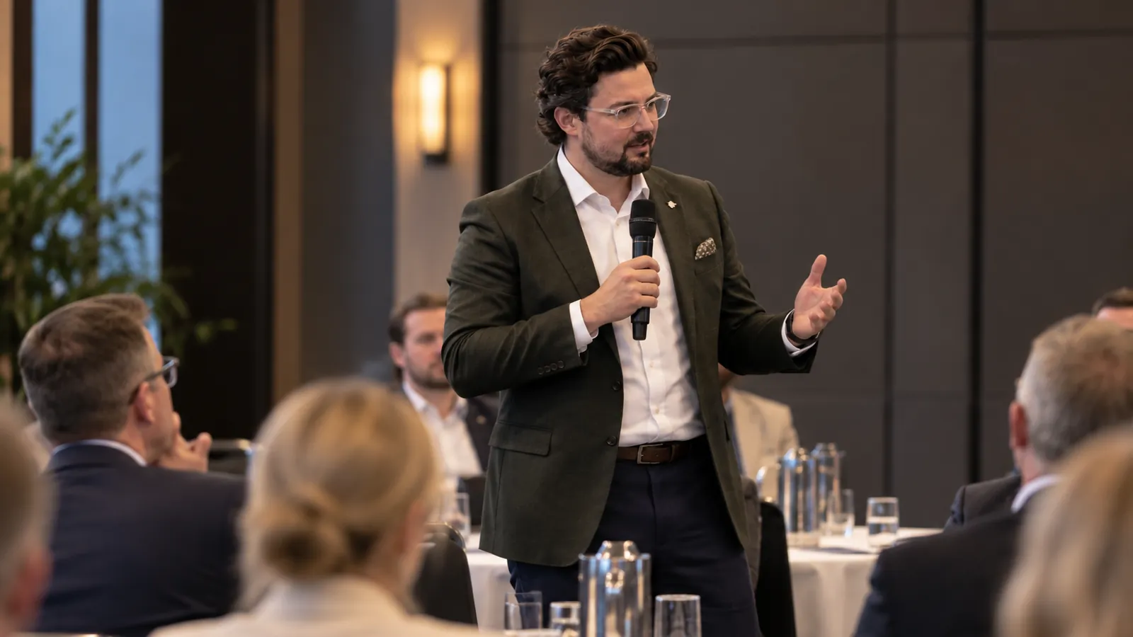 Joshua Baldwin speaking to a seated audience at a professional forum